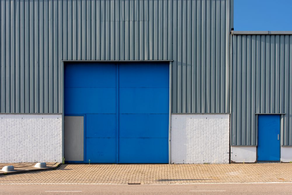 Blue and grey steel warehouse with large loading doors